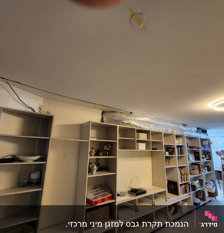 תקרת גבס עם חוטים חשמליים חשופים ותאורה עגולה